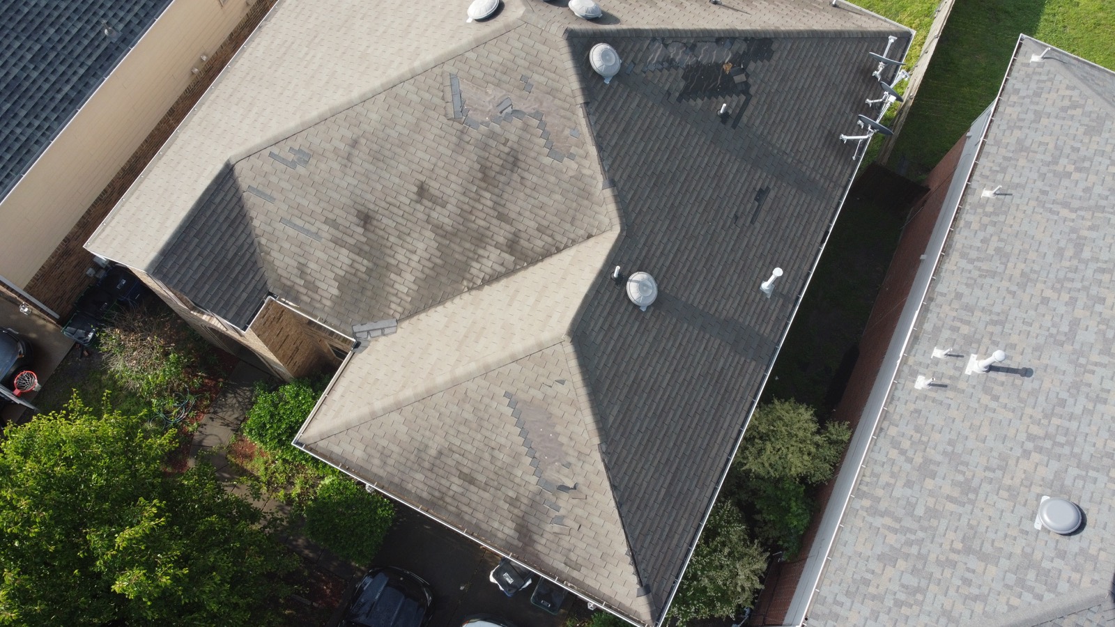 Aerial drone view of a multi-plane residential shingle roof inspected by First Choice Roofing